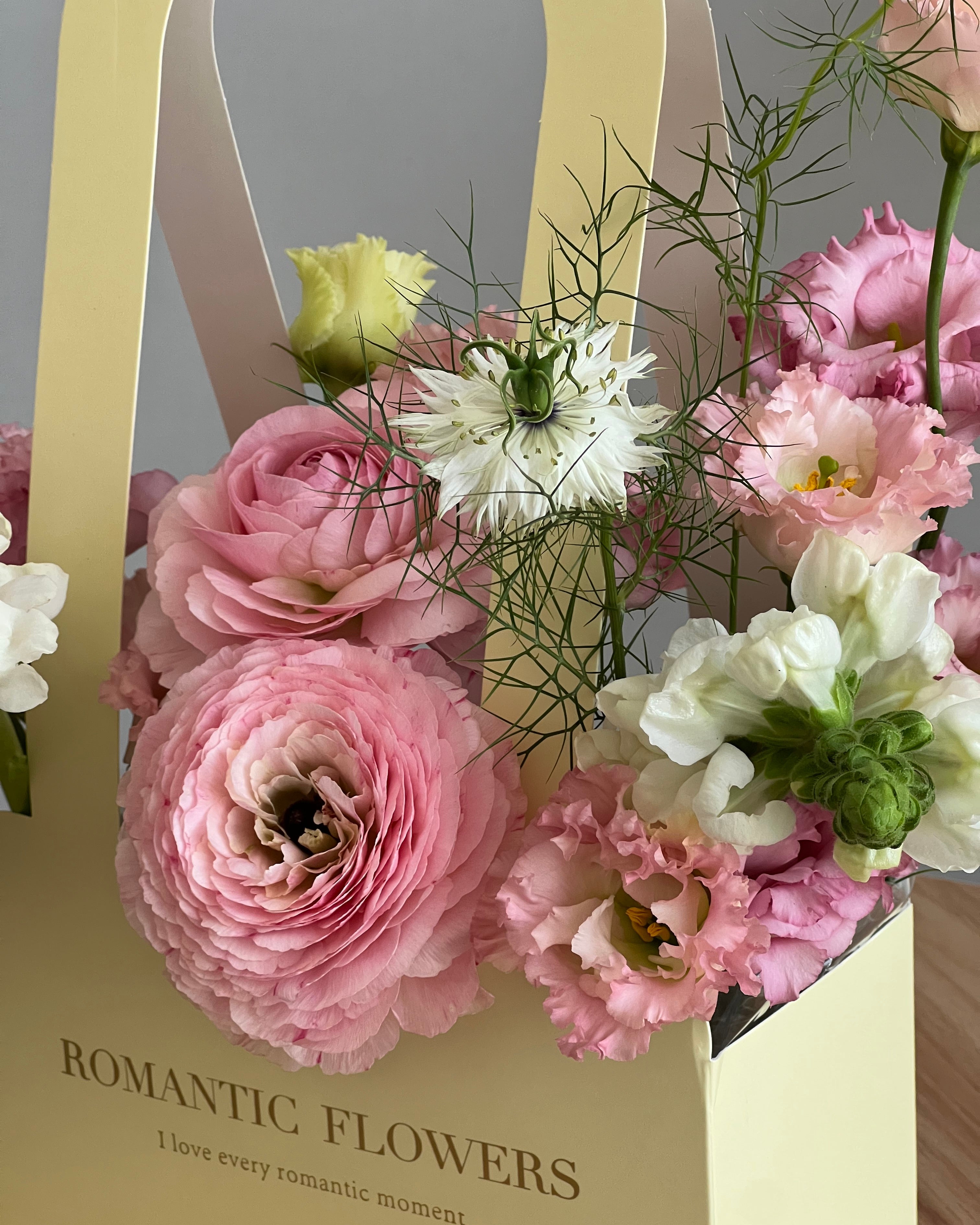 Bouquet of pink and white flowers with a 'Romantic Flowers' box in the background.