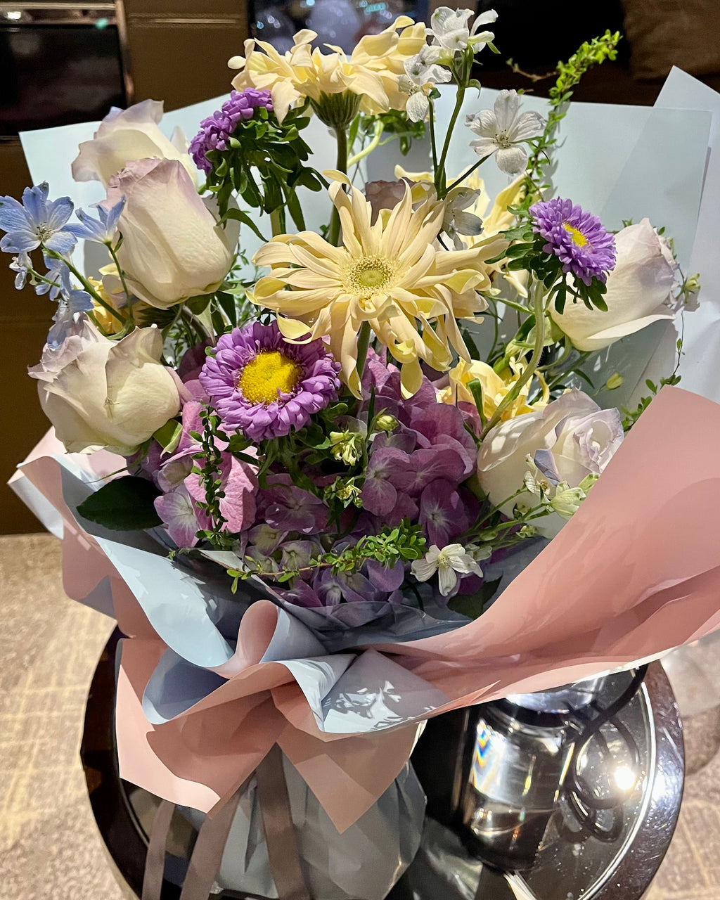 Bouquet of flowers held by a person in an indoor setting